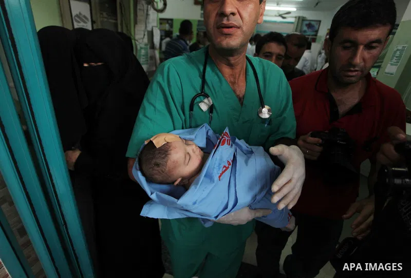 Palestinian medics treat an infant, whom medics said was wounded in an Israeli air strike, at a hospital in Rafah in the southern Gaza Strip August 4, 2014. A brief Israeli truce to allow aid to reach Palestinians ended...
