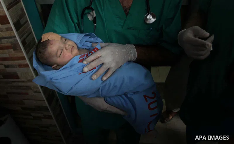 Palestinian medics treat an infant, whom medics said was wounded in an Israeli air strike, at a hospital in Rafah in the southern Gaza Strip August 4, 2014. A brief Israeli truce to allow aid to reach Palestinians ended...