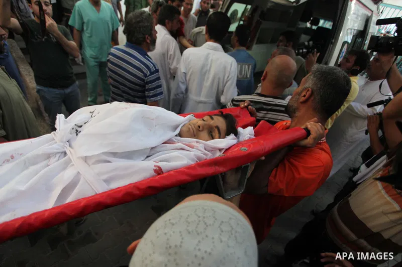 Palestinian mourners carry the body of eleven-year-old Mohammed Eweda, who medics said was killed along with his five-year-old sister Amal in an Israeli military strike on their house, during their funeral in Rafah in th...