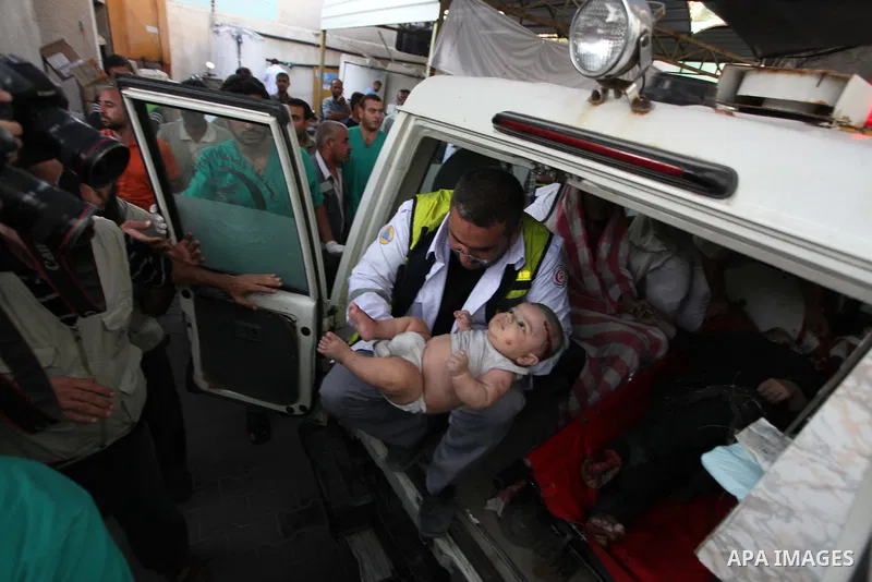 Palestinian medics treat an infant, whom medics said was wounded in an Israeli air strike, at a hospital in Rafah in the southern Gaza Strip August 4, 2014. A brief Israeli truce to allow aid to reach Palestinians ended...