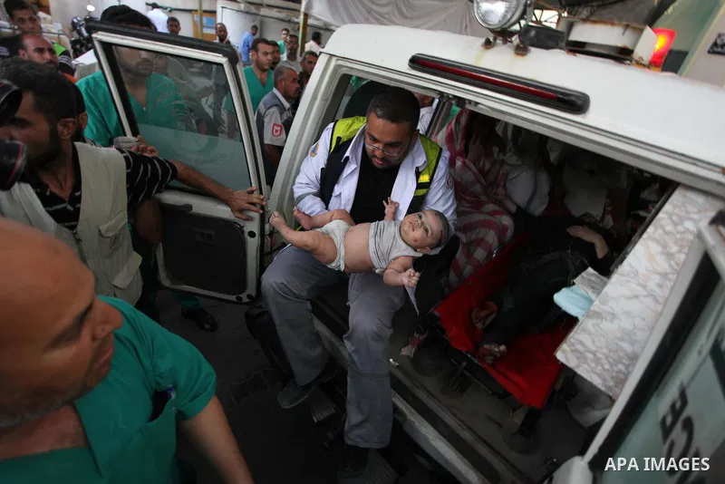 Palestinian medics treat an infant, whom medics said was wounded in an Israeli air strike, at a hospital in Rafah in the southern Gaza Strip August 4, 2014. A brief Israeli truce to allow aid to reach Palestinians ended...