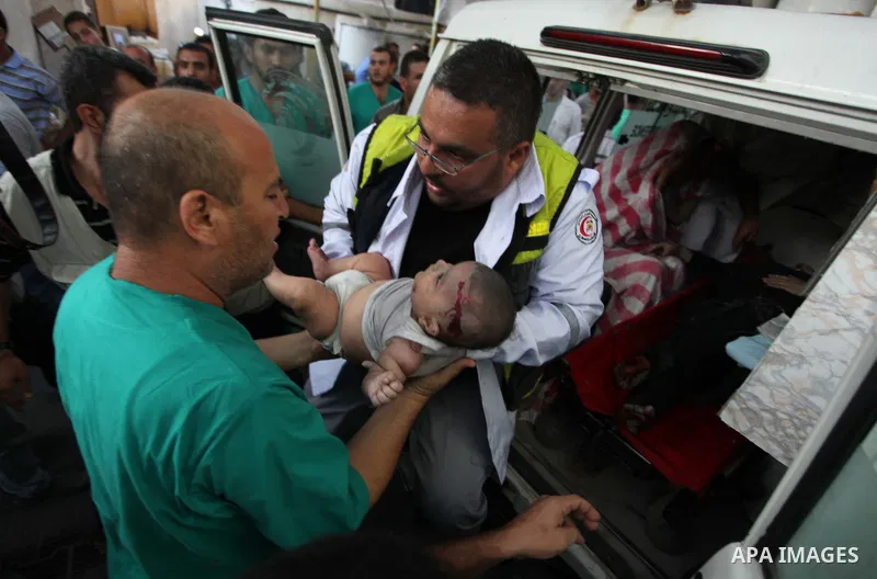 Palestinian medics treat an infant, whom medics said was wounded in an Israeli air strike, at a hospital in Rafah in the southern Gaza Strip August 4, 2014. A brief Israeli truce to allow aid to reach Palestinians ended...