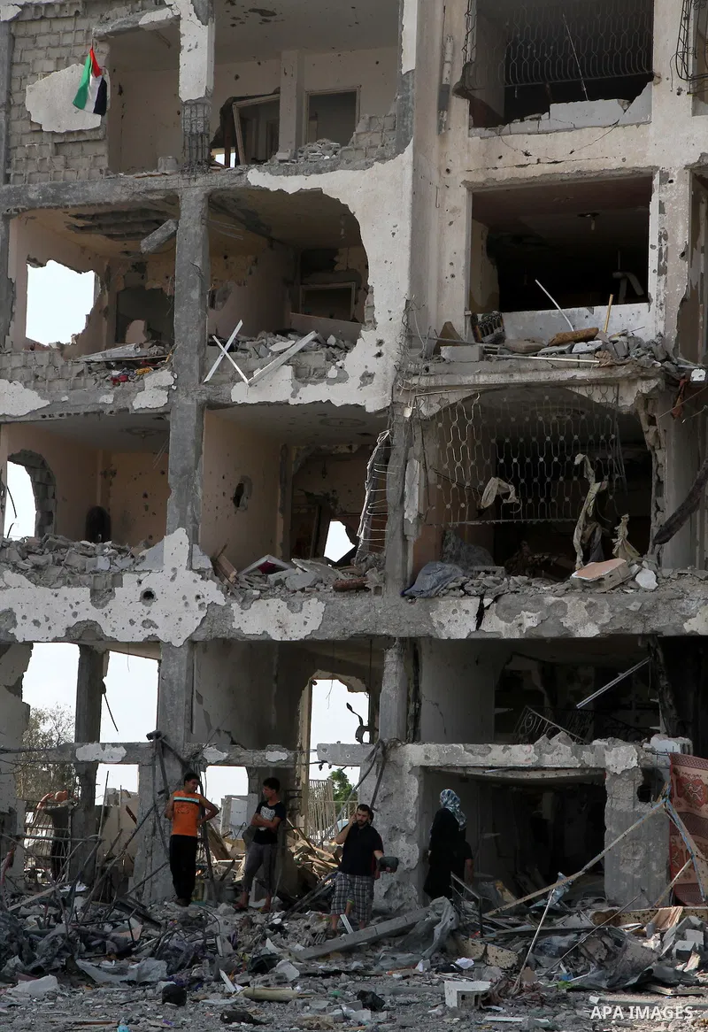 Palestinians inspect a destroyed houses as they return to their house in Beit Lahiya town, which witnesses said was heavily hit by Israeli shelling and air strikes during the Israeli offensive, in the northern Gaza Strip...