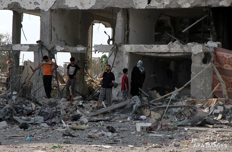 Palestinians inspect a destroyed houses as they return to their house in Beit Lahiya town, which witnesses said was heavily hit by Israeli shelling and air strikes during the Israeli offensive, in the northern Gaza Strip...