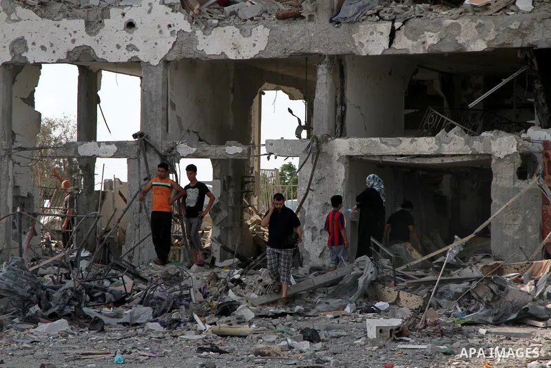 Palestinians inspect a destroyed houses as they return to their house in Beit Lahiya town, which witnesses said was heavily hit by Israeli shelling and air strikes during the Israeli offensive, in the northern Gaza Strip...
