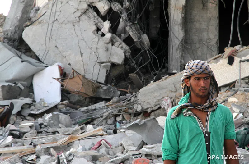 A Palestinian carries his belonging A Palestinian man walks past destroyed buildings as he walks past a badly damaged residential building after returning to Beit Lahiya town, which witnesses said was heavily hit by Isra...