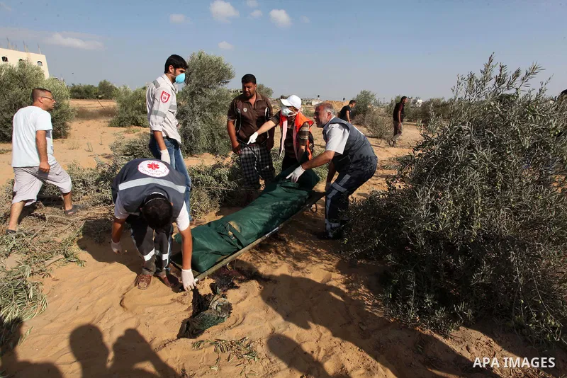 Medics carry the dead body of a Palestinian man after removing it from under the rubble of a house which witnesses said was destroyed during the Israeli offensive, in the east of Rafah in the southern Gaza Strip August 5...
