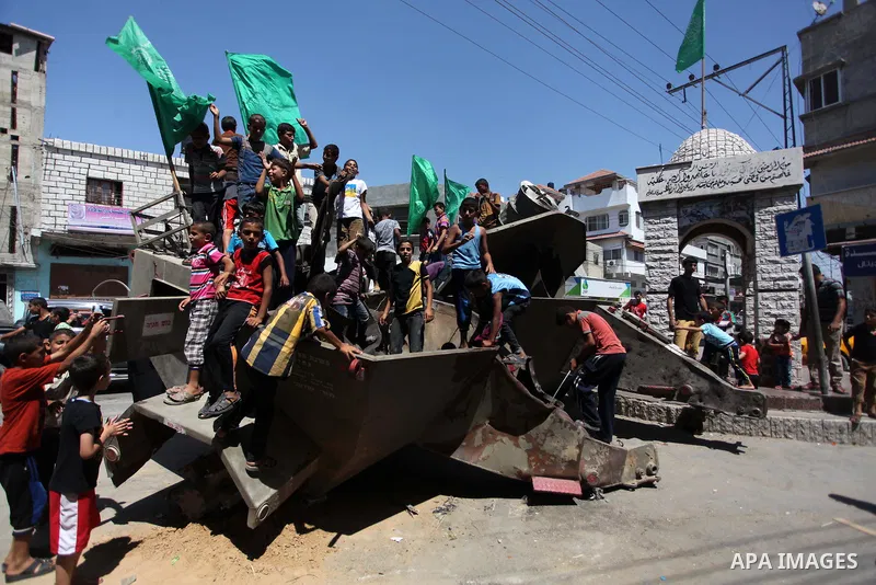 Palestinian children play on the remains of a destroyed Israeli military vehicle, in the east of Khan Younis in the southern Gaza Strip August 5, 2014. Israel pulled its ground forces out of the Gaza Strip on Tuesday and...