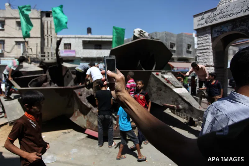 Palestinian children play on the remains of a destroyed Israeli military vehicle, in the east of Khan Younis in the southern Gaza Strip August 5, 2014. Israel pulled its ground forces out of the Gaza Strip on Tuesday and...
