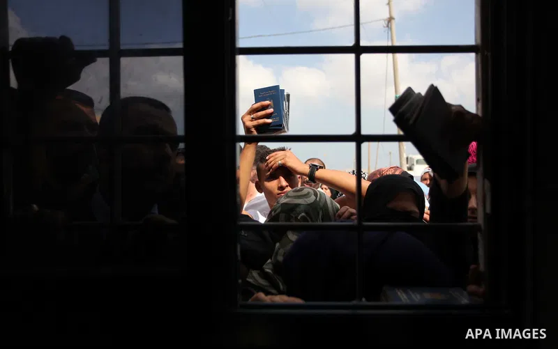 People, hoping to cross into Egypt, stand behind a gate as they wait at the Rafah crossing between Egypt and the southern Gaza Strip August 5, 2014. Israel pulled its ground forces out of the Gaza Strip on Tuesday and be...