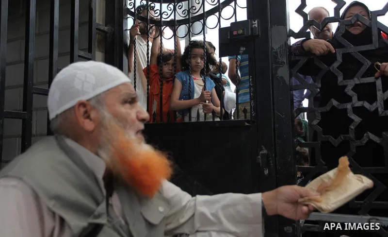 People, hoping to cross into Egypt, stand behind a gate as they wait at the Rafah crossing between Egypt and the southern Gaza Strip August 5, 2014. Israel pulled its ground forces out of the Gaza Strip on Tuesday and be...