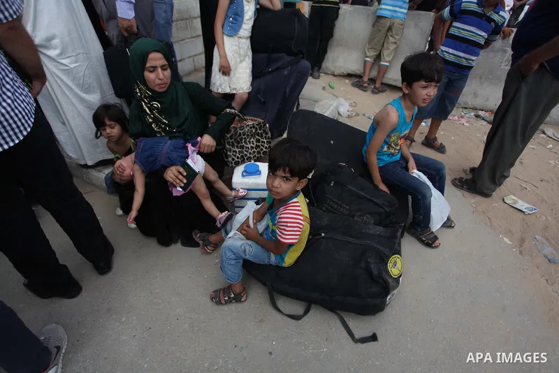 People, hoping to cross into Egypt, stand behind a gate as they wait at the Rafah crossing between Egypt and the southern Gaza Strip August 5, 2014. Israel pulled its ground forces out of the Gaza Strip on Tuesday and be...