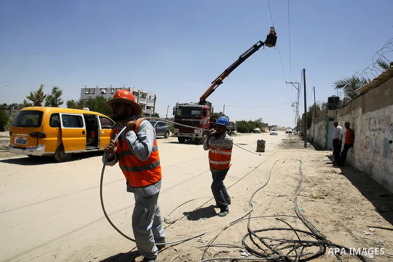 Palestinian workers drag a power cable, which witnesses said was damaged during the Israeli offensive, in the east of Rafah in the southern Gaza Strip August 6, 2014. Israel pulled its last soldiers out of the Gaza Strip...