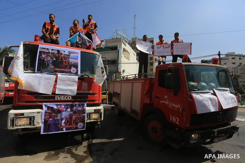 Palestinian members of civil defense take part a protest against the Israeli aggression on them during the war on Gaza Strip, in Gaza city on August 7, 2014. The ceasefire, which came into effect on August 5, has brought...