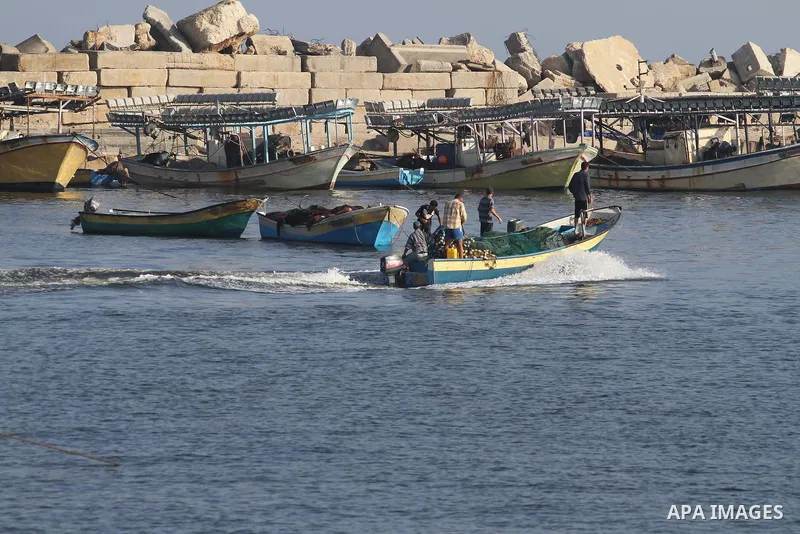 Palestinian fishermen work on their boats at Gaza seaport on in Gaza city on August 7, 2014. The ceasefire, which came into effect on August 5, has brought relief to both sides after one month of fighting killed 1,875 Pa...