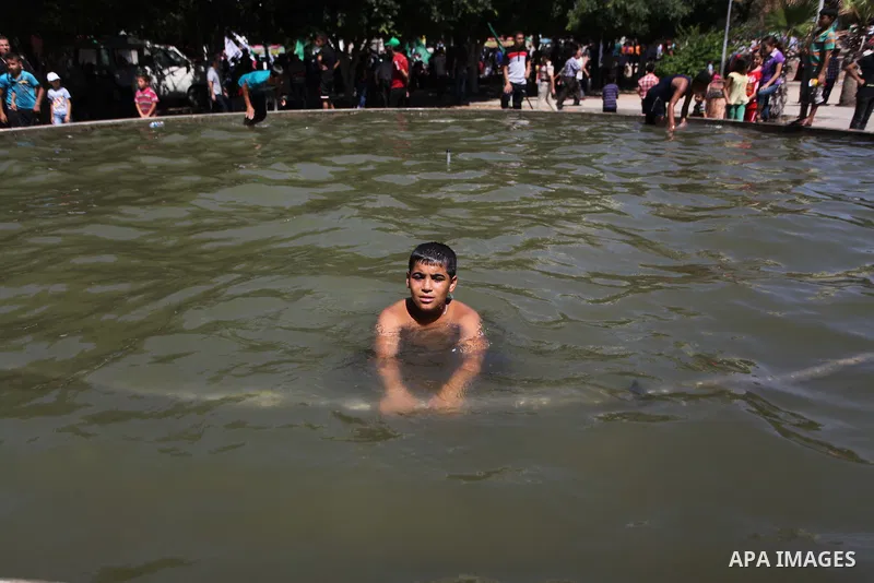 A Palestinian boy swims in a pool at a park in Gaza city on August 07, 2014. Indirect Israeli-Palestinian negotiations over extending a cease-fire in the Gaza Strip and ending a blockade of the battered territory got und...