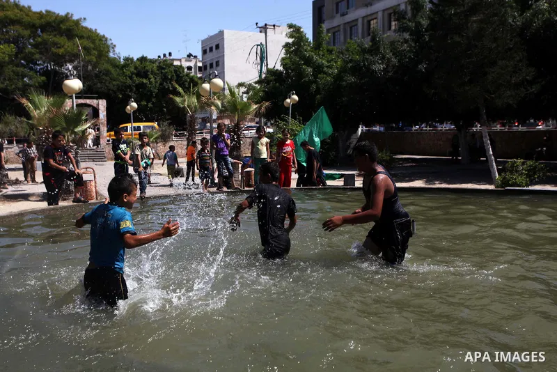 Palestinian children swim in a pool at a park in Gaza city on August 07, 2014. Indirect Israeli-Palestinian negotiations over extending a cease-fire in the Gaza Strip and ending a blockade of the battered territory got u...