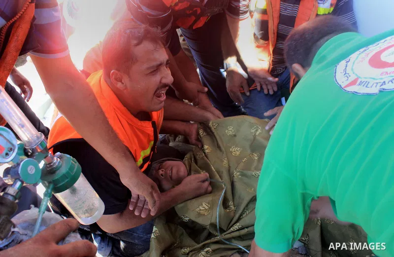 Palestinian rescue workers treat an injured woman who have been evacuated from under the rubble of a destroyed house following an Israeli air strike in Gaza city on August 08, 2014. Israel launched air strikes across the...