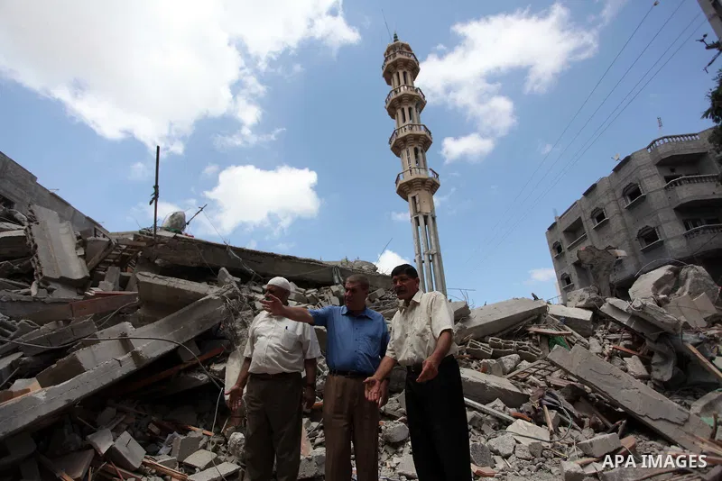 Palestinians look at the remains of al-Qassam mosque, which witnesses said was hit by an Israeli air strike, in Nuseirat refugee camp in the central Gaza Strip on August 9, 2014. Israel launched more than 20 aerial attac...
