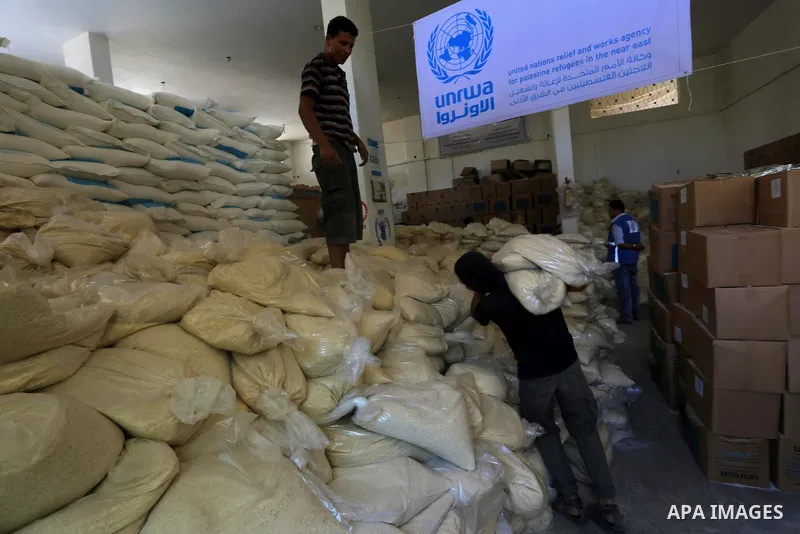 A Palestinian man carries bags of rice at a distribution centre of the United Nations Relief and Works Agency (UNRWA) in Gaza City on August 11, 2014. An Israeli delegation arrived in Cairo for indirect negotiations with...