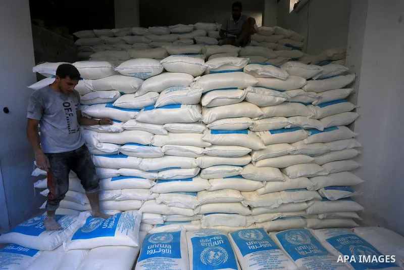 A Palestinian man stand on the bags of flour at a distribution centre of the United Nations Relief and Works Agency (UNRWA) in Gaza City on August 11, 2014. An Israeli delegation arrived in Cairo for indirect negotiation...