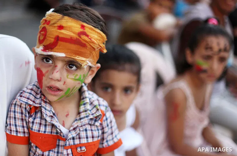 Palestinians celebrate during the wedding ceremony of a displaced couple at a United Nations-run school sheltering displaced Palestinians from the Israeli offensive, in Shati refugee camp in Gaza City August 13, 2014. Th...