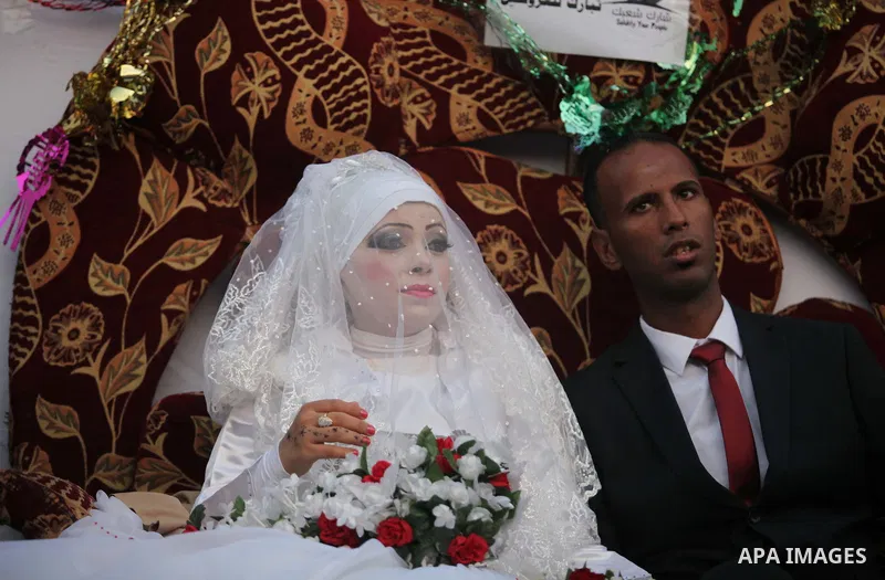 A Palestinian couple celebrate their wedding ceremony at a United Nations-run school sheltering displaced Palestinians from the Israeli offensive, in Shati refugee camp in Gaza City August 13, 2014. The threat of renewed...
