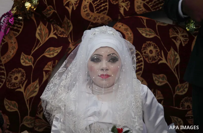 A Palestinian couple celebrate their wedding ceremony at a United Nations-run school sheltering displaced Palestinians from the Israeli offensive, in Shati refugee camp in Gaza City August 13, 2014. The threat of renewed...