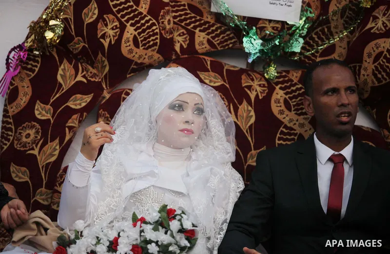 A Palestinian couple celebrate their wedding ceremony at a United Nations-run school sheltering displaced Palestinians from the Israeli offensive, in Shati refugee camp in Gaza City August 13, 2014. The threat of renewed...
