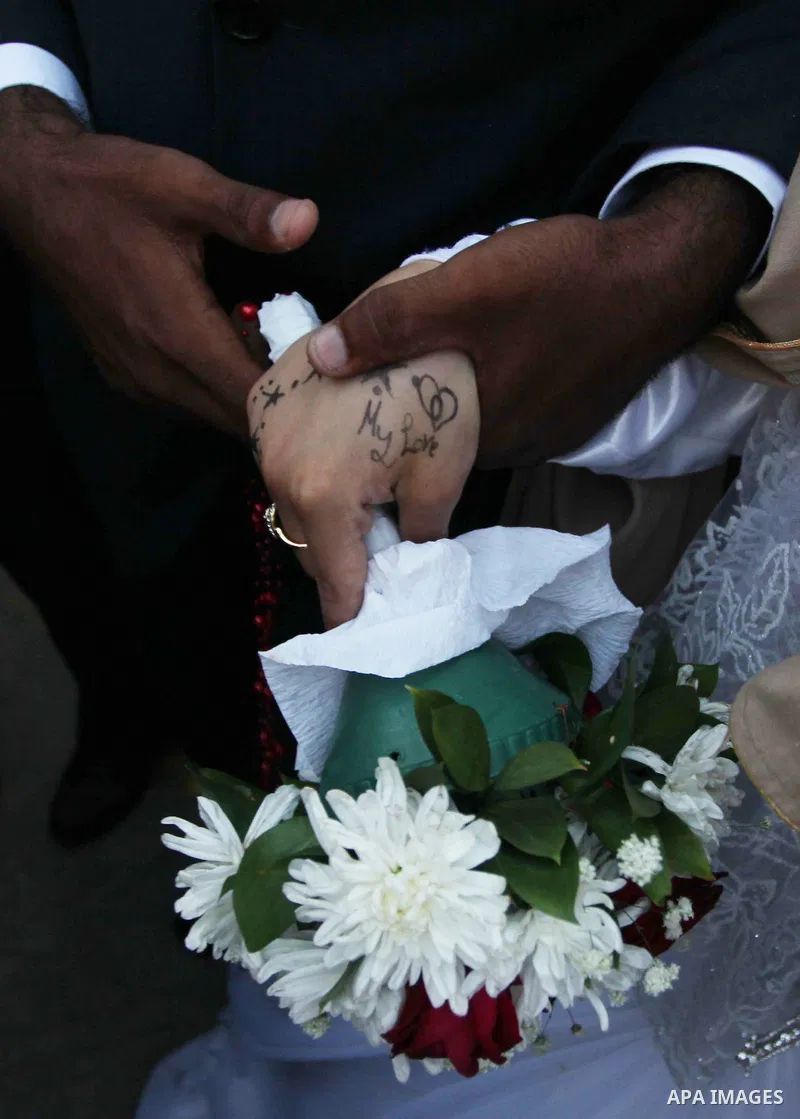 A Palestinian couple celebrate their wedding ceremony at a United Nations-run school sheltering displaced Palestinians from the Israeli offensive, in Shati refugee camp in Gaza City August 13, 2014. The threat of renewed...