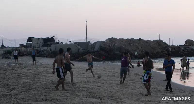 Palestinians take a dip in the sea as the sun sets over the Gaza City, on August 14, 2014.A fresh five-day ceasefire between Palestinian militants and Israel went into force early Thursday, agreed at the end of a three-d...