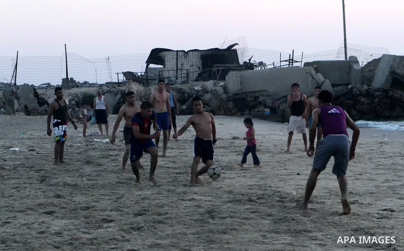 Palestinians take a dip in the sea as the sun sets over the Gaza City, on August 14, 2014.A fresh five-day ceasefire between Palestinian militants and Israel went into force early Thursday, agreed at the end of a three-d...