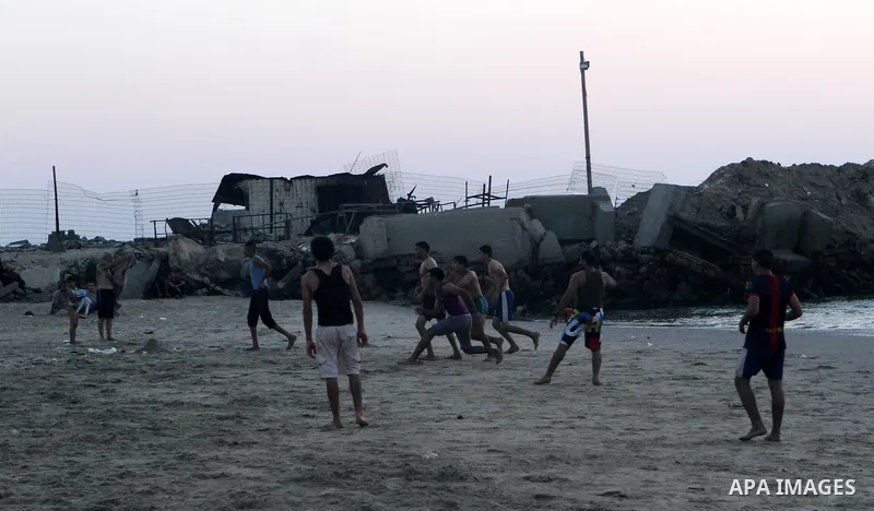 Palestinians take a dip in the sea as the sun sets over the Gaza City, on August 14, 2014.A fresh five-day ceasefire between Palestinian militants and Israel went into force early Thursday, agreed at the end of a three-d...