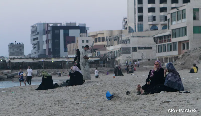 Palestinians take a dip in the sea as the sun sets over the Gaza City, on August 14, 2014.A fresh five-day ceasefire between Palestinian militants and Israel went into force early Thursday, agreed at the end of a three-d...