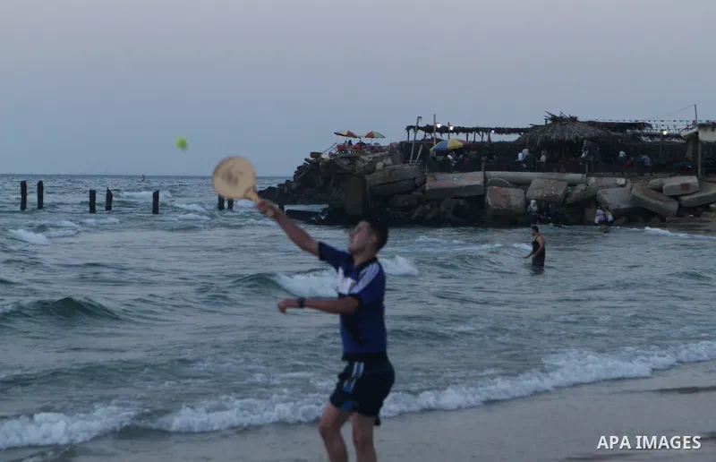 Palestinians take a dip in the sea as the sun sets over the Gaza City, on August 14, 2014.A fresh five-day ceasefire between Palestinian militants and Israel went into force early Thursday, agreed at the end of a three-d...