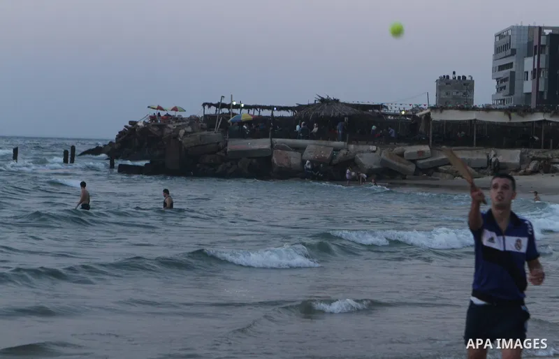 Palestinians take a dip in the sea as the sun sets over the Gaza City, on August 14, 2014.A fresh five-day ceasefire between Palestinian militants and Israel went into force early Thursday, agreed at the end of a three-d...