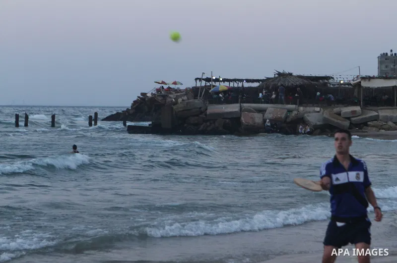 Palestinians take a dip in the sea as the sun sets over the Gaza City, on August 14, 2014.A fresh five-day ceasefire between Palestinian militants and Israel went into force early Thursday, agreed at the end of a three-d...