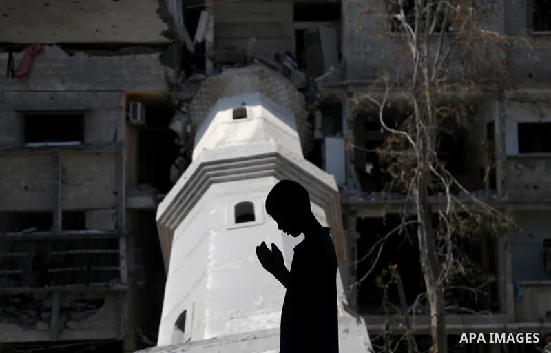 A Palestinian boy prays at a mosque which witnesses said was destroyed by an Israel air strike during the offensive, on the second day of a five-day ceasefire, in Gaza city on August 15, 2014. Israel and Palestinians are...