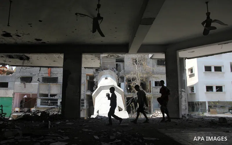 Palestinian boys inspect the damage at a mosque which witnesses said was destroyed by an Israel air strike during the offensive, on the second day of a five-day ceasefire, in Gaza city on August 15, 2014. Israel and Pale...