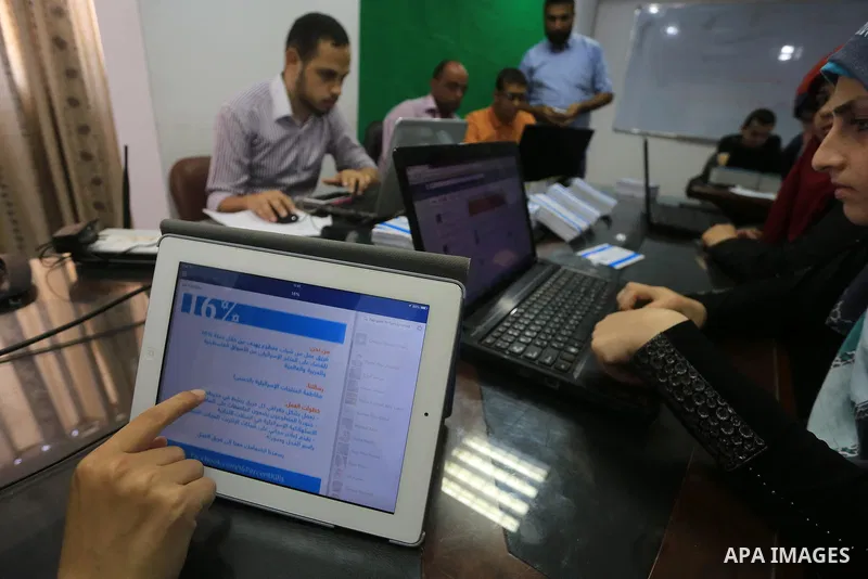 Palestinian youths take part in a campaign to boycott Israeli goods following the Israeli military offensive on Gaza Strip in Gaza City on Aug. 16, 2014. Photo by Mohammed Asad