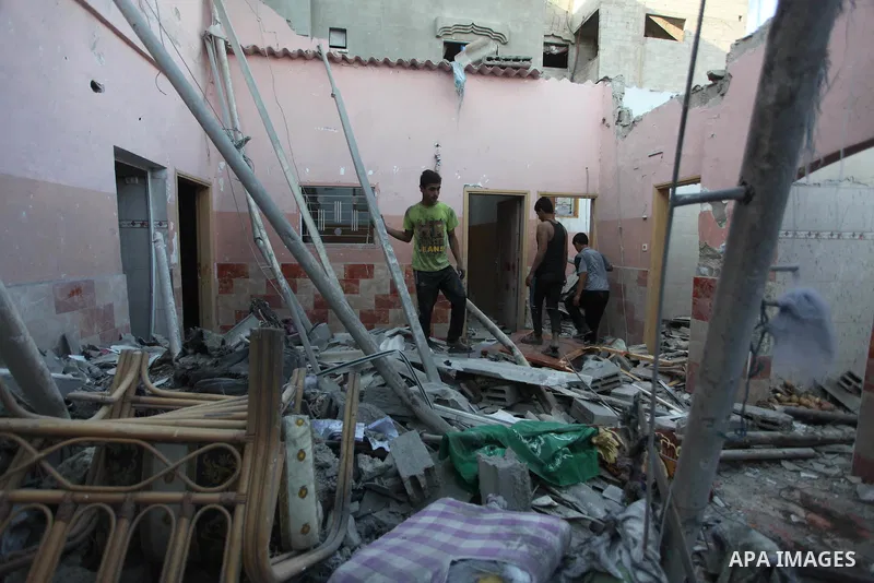 Palestinians inspect a house that witnesses said was damaged during an Israeli air strike in the Jabalia Palestinian refugee camp in the Gaza Strip on August 20, 2014. Hamas said that an Israeli air strike killed the wif...