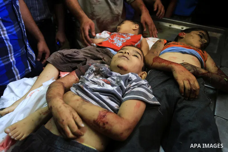 Palestinians gather around the bodies of three children from the Al-Rifi family upon their arrival at Gaza city's Al-Shifa hospital on August 21, 2014. Three senior Hamas commanders and four children were among at least...