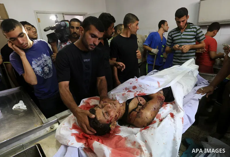 Palestinians gather around the body of Palestinian man upon their arrival at Gaza city's Al-Shifa hospital on August 21, 2014. Three senior Hamas commanders and four children were among at least 15 Palestinians killed in...