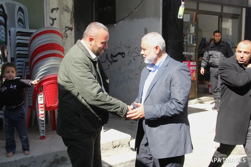 A handout picture dated February 26, 2014 and released by Hamas Press Office on August 21, 2014, shows the top Hamas official in Gaza Ismail Haniya (C-R) greeting fellow senior Hamas commander, Raed al-Atar (L), in the s...