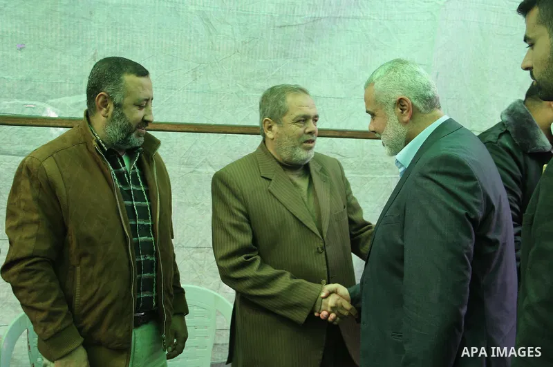 A handout picture dated February 26, 2014 and released by Hamas Press Office on August 21, 2014, shows the top Hamas official in Gaza Ismail Haniya (R) greeting fellow senior Hamas commander, Mohammed Abu Shamala (L), in...
