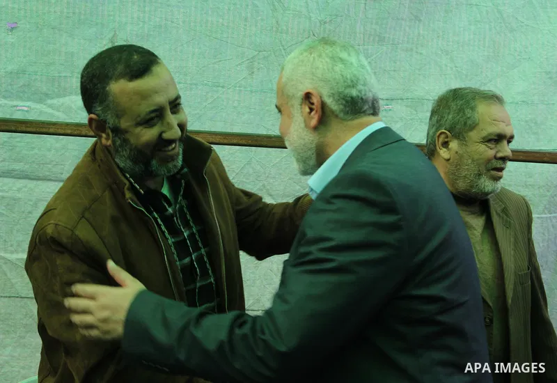 A handout picture dated February 26, 2014 and released by Hamas Press Office on August 21, 2014, shows the top Hamas official in Gaza Ismail Haniya (R) greeting fellow senior Hamas commander, Mohammed Abu Shamala (L), in...