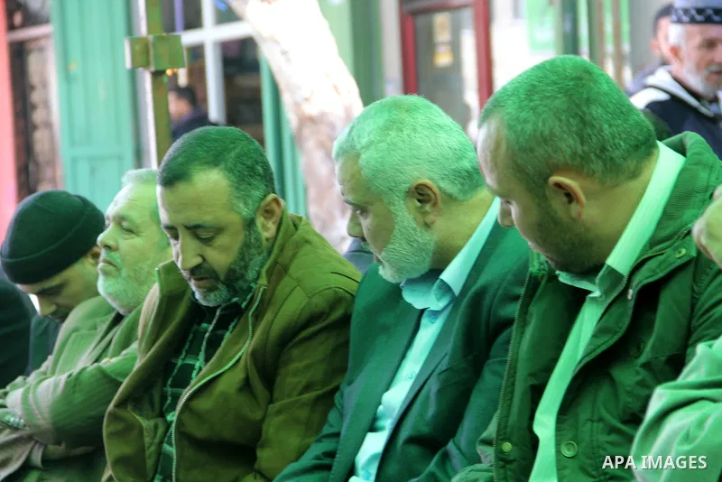A handout picture dated February 26, 2014 and released by Hamas Press Office on August 21, 2014, shows the senior Hamas commander, Raed al-Atar (R), with the top Hamas official in Gaza Ismail Haniya (C) and senior Hamas...