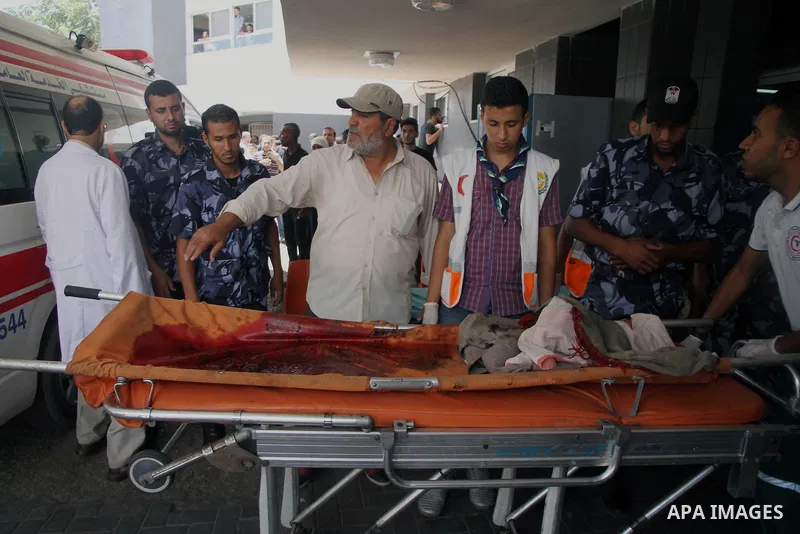 Palestinians mourn over the body of his relative Rami Abu Nahel, killed in an Israeli military strike, at Gaza city's Al-Shifa hospital on August 21, 2014. Three senior Hamas commanders and four children were among at le...