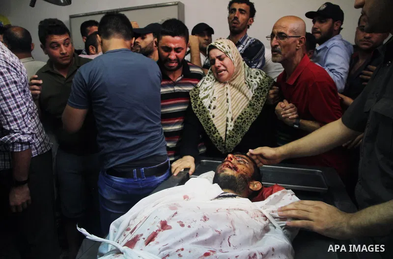 Palestinians mourn over the body of his relative Rami Abu Nahel, killed in an Israeli military strike, at Gaza city's Al-Shifa hospital on August 21, 2014. Three senior Hamas commanders and four children were among at le...