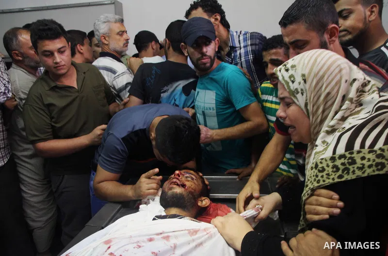 Palestinians mourn over the body of his relative Rami Abu Nahel, killed in an Israeli military strike, at Gaza city's Al-Shifa hospital on August 21, 2014. Three senior Hamas commanders and four children were among at le...